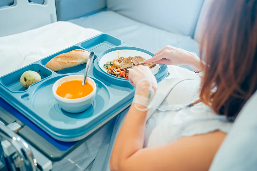 sick woman eating food in the hospital