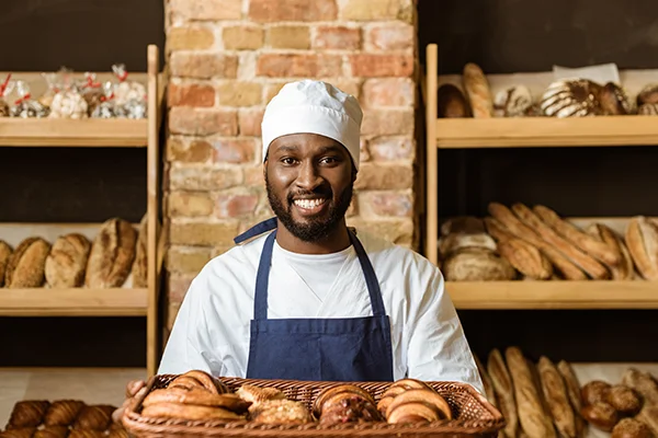 smiling baker holding baked goods basket